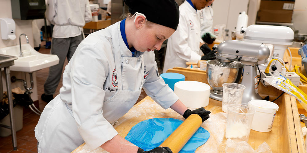 A culinary student in a baking and cake decorating class.